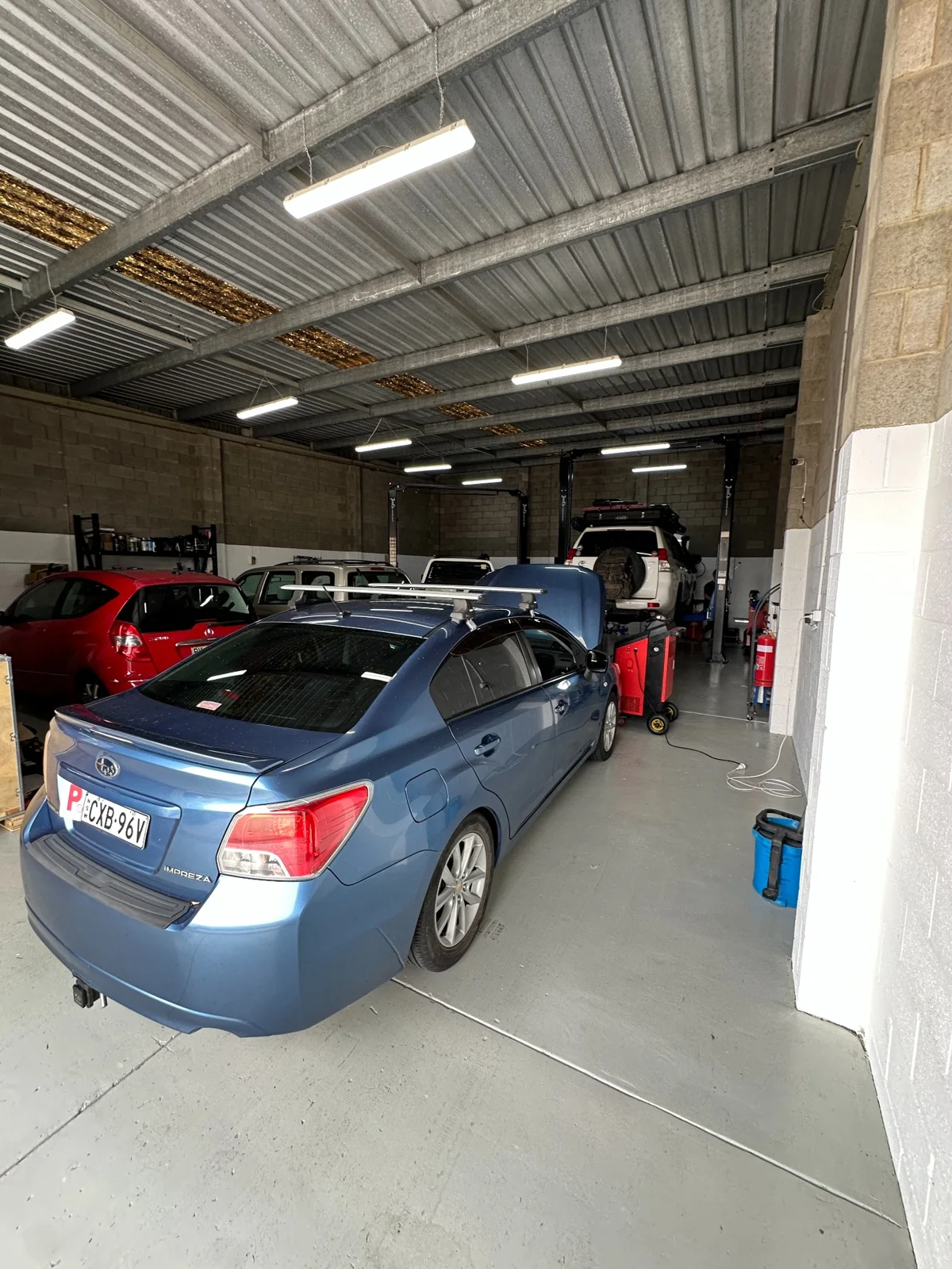 Subaru Impreza and customer vehicles inside the TF Performance Automotive workshop